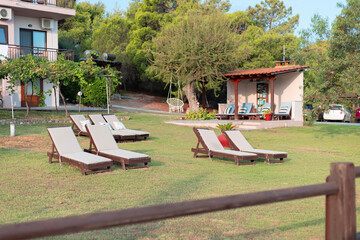 a resting place, sun beds on a green lawn on the territory of the hotel