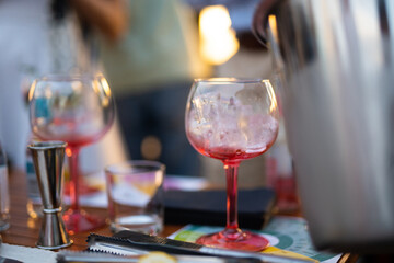 the bartender prepares an alcoholic cocktail by pouring ice cubes into a glass