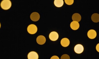 Golden christmas lights on black background Golden bokeh Blurry lights Celebration Abstract golden glitter background Wallpaper and banner Generative AI