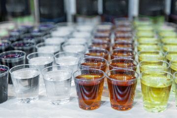 many glasses with strong alcohol stand on the table ready to drink