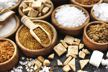 Mix of sugar varieties: unbleached, brown and white, refined and unrefined, granulated and cubes; selective focus