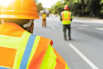 Construction Team in Safety Gear Working Together on Road Construction Site