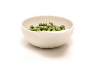 白背景の白い陶器のボウルに入れたグリーンピース