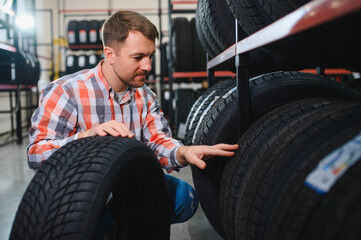 Man chooses winter car tires in the auto shop