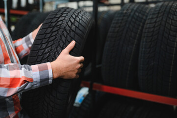 Tire repair service. A man chooses new tires for his car.