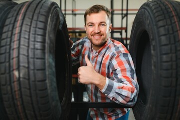 Fototapeta premium Man chooses winter car tires in the auto shop
