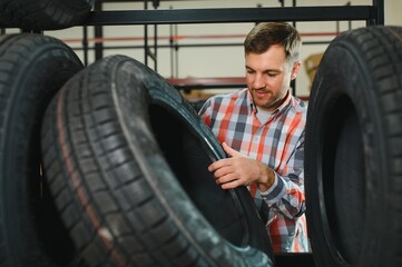 Man chooses winter car tires in the auto shop