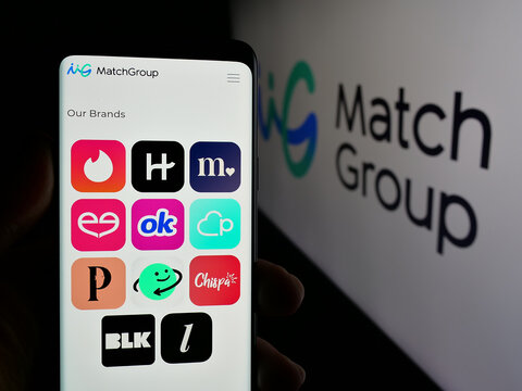 Stuttgart, Germany - 01-20-2025: Person holding smartphone with web page of US online dating company Match Group Inc. on screen in front of logo. Focus on center of phone display.