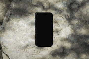 Phone with the blank black screen on the rock