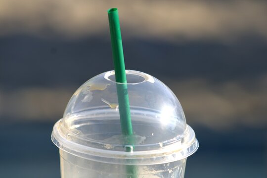 domed plastic lid and green straw on coffee cup