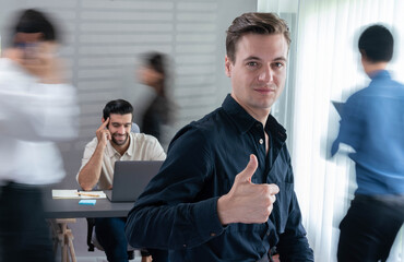 Confidence and happy smiling businessman portrait with blur motion background of his colleague and business team working in office. Office worker teamwork and positive workplace concept. Prudent