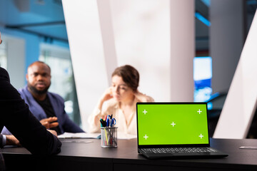 Salesman in dealership using green screen laptop, negotiating price and extra car features to help solidify deal. Agent persuading hesitant customers to buy vehicle using mockup notebook