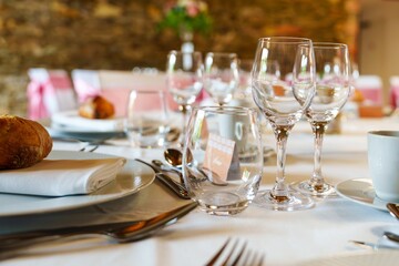 This elegant table setting showcases wine glasses, a freshly baked bread roll, and a beautifully folded napkin, creating the perfect ambiance for a romantic dinner or special celebration.