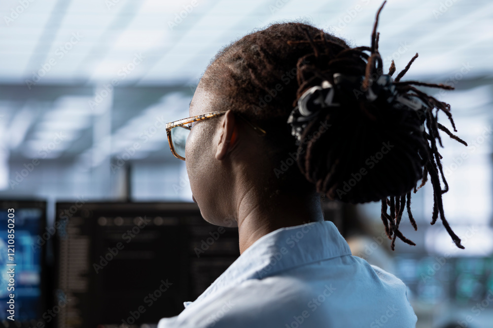 Poster woman sitting at computer desk, finishing programming tasks in ai data center used for machine learn