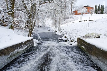 The image depicts a stunning winter landscape featuring a river winding through snow-covered banks...