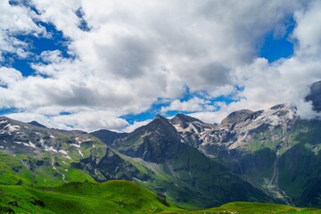 Fototapeta premium This stunning image showcases the majestic mountains of Kaprun, Austria, featuring snow-capped peaks and lush green hills. A paradise for nature lovers, it invites exploration and adventure.