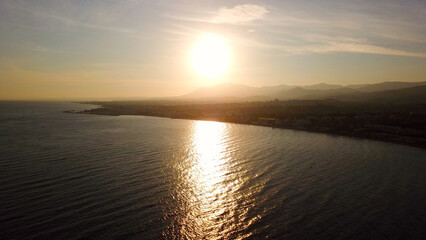 Fototapeta premium aerial view of the sunset near Marbella with a view towards Puerto Banús marina and Estepona with mountains behind, Marbella, Malaga, Andalusia, Costa del Sol, Spain