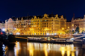 Obraz premium The Vltava River flows through the heart of Prague, Czech Republic, passing by many historic buildings and landmarks, and is a popular tourist destination for those visiting the capital city.
