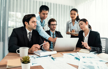 Diverse group of business analyst team analyzing financial data report paper on office table. Chart and graph dashboard by business intelligence analysis for strategic marketing planning Habiliment