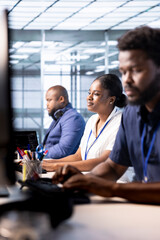 Smiling data center engineer next to colleagues using programming languages to construct algorithms and build applications. Cheerful server hub employee debugging and optimizing code