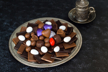 Traditional Turkish Chocolates designed on metal plate with colorful candies and coffee