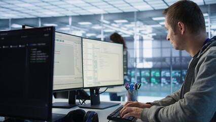 System administrator in server room doing system analysis, coding supercomputers. Specialist working in high tech facility housing advanced storage infrastructure, camera B close up