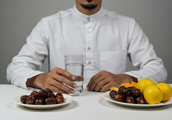 Close-Up of Hands Preparing to Break Fast with a Glass of Water and Fresh Fruits on the Table