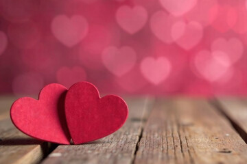Obraz premium two pink hearts stand on a wooden background