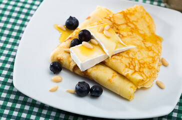 Delicious tasty homemade crepes served with soft cheese and honey