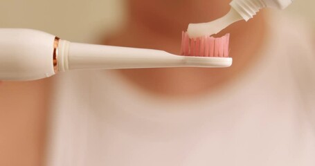 close up 4k woman mouth smiling using electric toothbrush and toothpaste. beautiful whitening smile, lips. natural teeth. dental care concept. oral hygiene, daily routine,morning or evening procedure