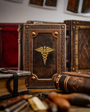 old book with the caduceus symbol surrounded with other old books