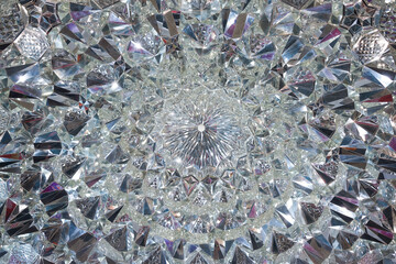 Crystal glass symmetrical design refracting light on its cut facets creating a sparkling background