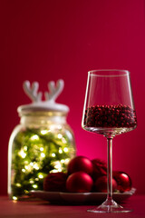 Christmas composition on a red background, balls, glass and garland