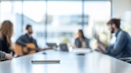 Blurred image of a business meeting with colleagues around a table.