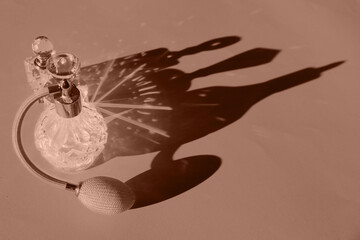 Perfume bottles on color background, toned in mocha mousse shade. Color of 2025 year
