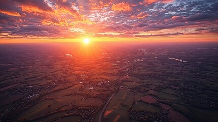 Stunning sunset over vast landscape with rolling hills and vibrant colors illuminating the sky