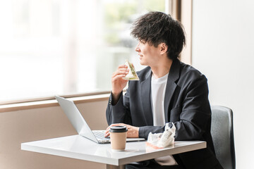 カフェでパソコンを使って仕事するビジネスマン・男性
