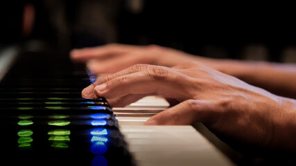 Close-Up of Hands Playing Piano with Vibrant Reflections