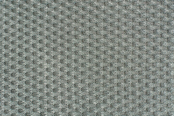 close-up of light neutral gray textured fabric background surface in full frame, raised bumpy grid like pattern abstract