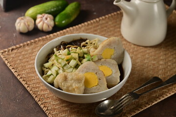 Pempek is a savory Palembang dish made of fish and tapioca, shaped and fried or boiled, served with tangy, sweet-spicy vinegar sauce called cuko.