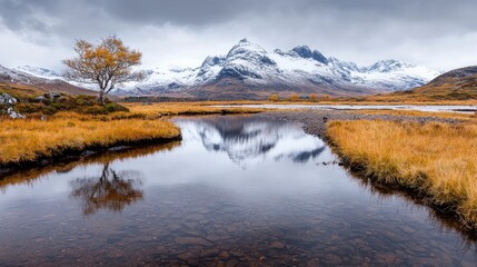 Fototapeta premium Autumnal Scottish Highlands, snow-capped mountains reflected in calm water, travel photography