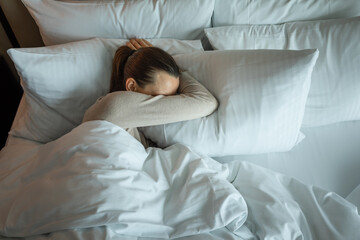 Sleepless woman lying in bed feeling tired stressed	