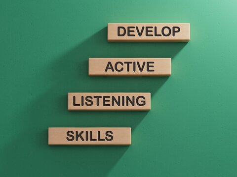 Listening skills symbol. Concept word Develop active listening skills on wooden blocks.Business and Develop active listening skills concept.3D rendering on green background.