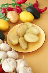 Fresh Produce: Potatoes, Lemons, and Garlic on a Yellow Background