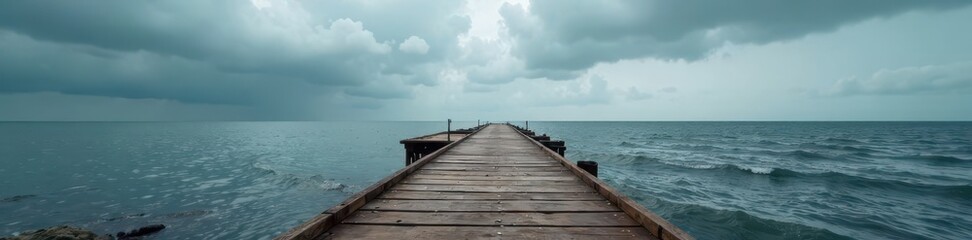 Fototapeta premium Rustic wooden pier stretches towards a dramatic, overcast sky above the grey sea , overcast, peaceful