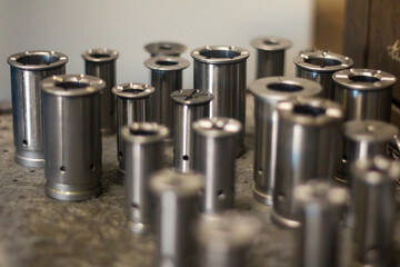 Shiny cylindrical metal machine tools like chrome in a manufacturing shop.