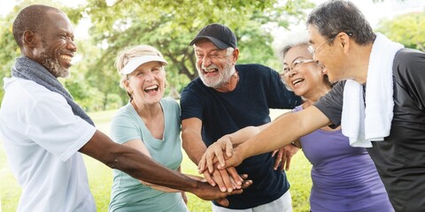 Group of diverse seniors enjoying outdoor exercise, smiling and bonding. Elderly friends, diverse seniors, outdoor fun, and exercise togetherness. Group of elderly people friends in park.