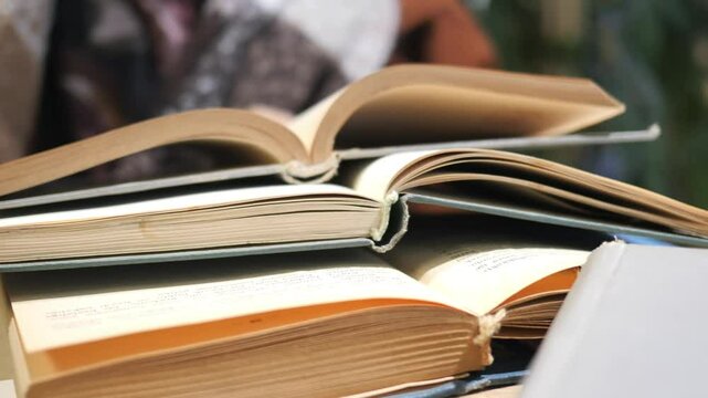 A stack of open books on a table creates warmth and comfort for readers