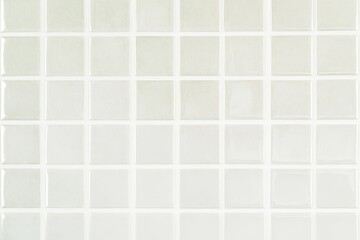 Fototapeta premium A grid of light-colored tiles arranged in even squares, creating a clean and minimalistic surface.
