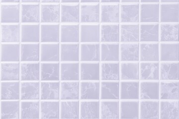 A smooth, light-colored tile mosaic featuring small square tiles arranged neatly in a grid pattern.